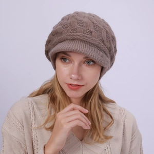 Detalle de la gorra de punto color topo con diseño de trenzas y visera corta abrigada