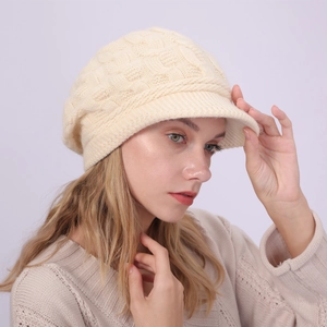 Primer plano detallado de la textura de punto de ochos en una gorra de lana beige para mujer