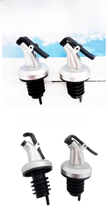 Close-up of four press-top dispenser spouts for oil bottles with silver finish and seals