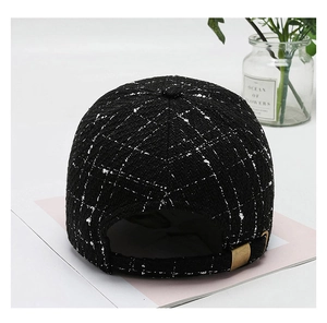 Detail of tweed baseball cap back with adjustable metal buckle and black plaid pattern