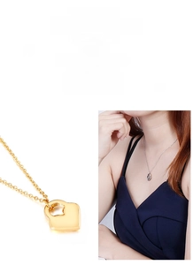 Detail of heart-shaped lock pendant necklace in gold and silver polished finishes