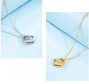 Detail of heart lock pendants on cross chains in polished gold and silver finishes