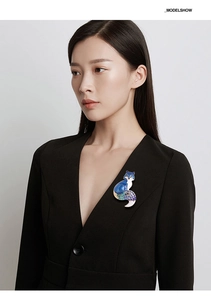 Detailed view of an elegant blue enamel fox brooch with crystal accents on a black blazer