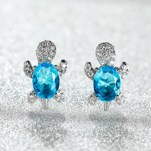 Creative sea turtle earrings with blue zircon stones and sparkling white crystals in silver