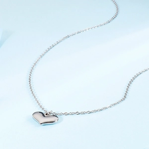Sleek silver heart pendant necklace on a delicate link chain over a light blue background