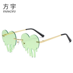 Detail view of heart-shaped rimless sunglasses with mint green fluid drip effect lenses