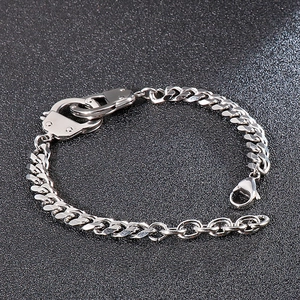 Detailed close-up of a silver Cuban link bracelet with unique handcuff style clasp