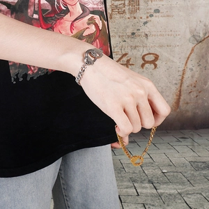 Detail of silver and gold handcuffs pendant bracelets with cuban links on a male wrist
