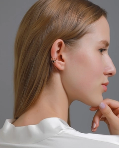 Close-up of a rose gold spider ear cuff with black gemstone on a female ear