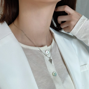 Close-up of minimalist 925 sterling silver heart pendant necklace on model