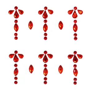 Macro detail of red acrylic face jewels with symmetrical teardrop and round gem designs