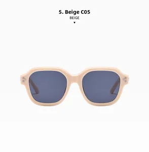 Detail view of beige irregular square sunglasses with retro metal rivets and grey lenses