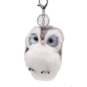 Cute grey and white faux rabbit fur owl keychain with blue eye details on white background