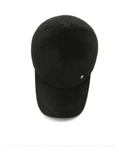 Detail of black thick faux fur baseball cap with small silver metal logo for winter