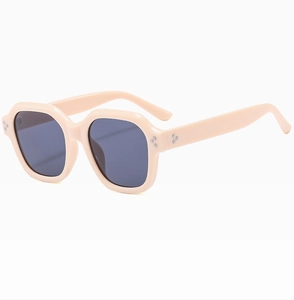 Detail of light pink hexagonal sunglasses frame with classic metal triple rivet accents