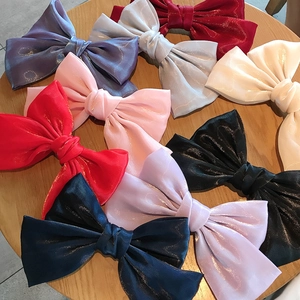 Detailansicht großer Satin-Haarspangen in verschiedenen Farben auf einem Holztisch