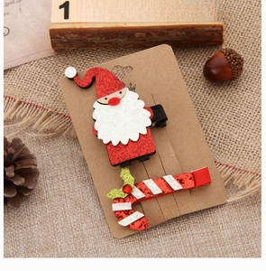 Detail of Santa Claus and candy cane hair clips with glitter finish on rustic background