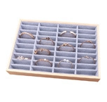 Detail view of 28 compartments wooden jewelry display tray with grey velvet lining