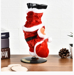 Babbo Natale elettrico che balla sulle mani con abito in peluche su tavolo rustico