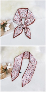 Detailed view of pink floral twilly scarf with red heart patterns and dark brown edges