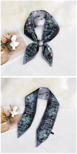 Detail of narrow silk scarf with tropical flamingo print and gray rolled edges
