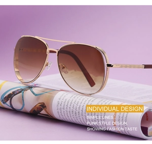 Macro shot of gold pilot sunglasses with brown gradient lenses on a magazine