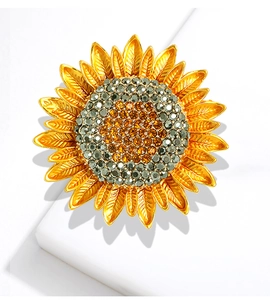 Detailed macro view of golden sunflower brooch with amber and grey crystal rhinestones