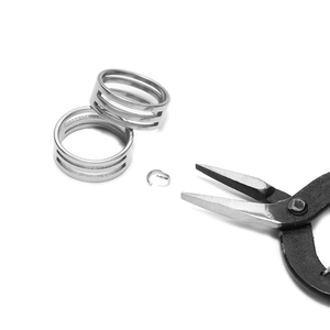 Detail of silver jump ring tool being used with pliers for jewelry making and repairs