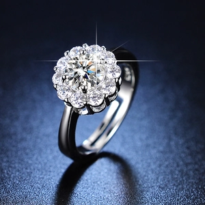 Classic silver six-prong engagement ring with round moissanite on a dark blue surface