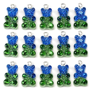 Macro shot of 15 glittery blue and green resin gummy bear charms with metal rings