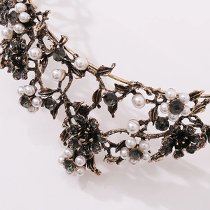 Macro detail of vintage gold floral tiara with black crystals and white pearls
