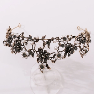 Detail view of vintage floral crown with black rhinestones and white pearls on stand