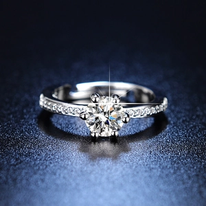 Macro shot of silver six-prong engagement ring with round center stone and pave accents