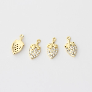 Detailed view of 18k gold strawberry charms with micro-paved white cubic zirconia