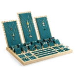 Detail view of emerald green velvet jewelry display set with bamboo wood base and slots