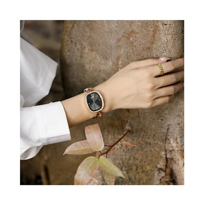 Elegant rose gold vintage oval watch and chain ring set shown in a natural outdoor setting