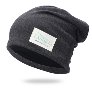 Dark grey ribbed knit beanie hat featuring a white fashion label and double-layer warmth