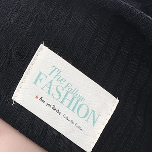 Black ribbed cotton beanie featuring a minimalist white rectangular woven label detail