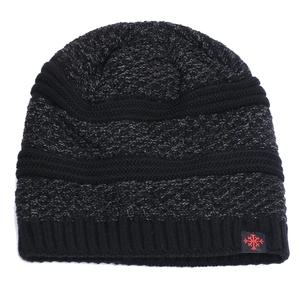 Detail of winter knit beanie showing black and grey mixed yarn texture and snowflake label
