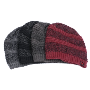 Close-up of thick knitted winter hats in multi-colors with warm fleece lining and snowflake label