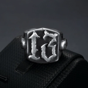 Macro shot of vintage silver skull ring featuring embossed number 13 on black leather