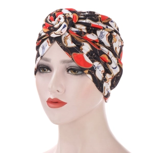 Close-up of turban cap with vintage red, gold, and black floral chain print
