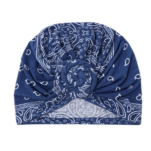 Detail of navy blue turban hat with paisley pattern and elegant spiral knot design