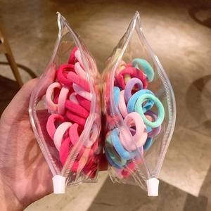Detail showing elastic hair ties in a portable clear zipper storage bag for girls