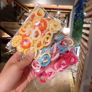 Macro shot of colorful high-elasticity hair bands in a daisy-patterned poly bag