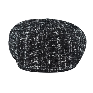 Detail of checkered newsboy cap in black and white tweed with subtle shimmering sequins