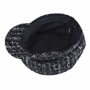 Macro view of black and white tweed newsboy cap with adjustable inner drawstring detail