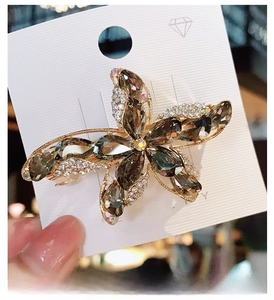 Close-up of a starfish hair clip with copper zircon and smoky grey K9 crystal stones