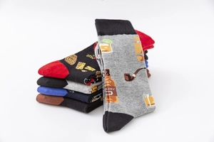 Detail of cotton crew socks featuring whisky, pipe, and barrel patterns on grey and black fabric