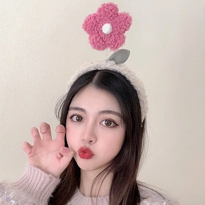 Detailed close-up of a soft plush fleece headband with a cute pink flower decoration